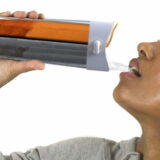Beautiful black woman drinking from her bidon after the workout