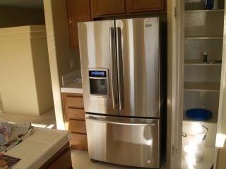 A highly polished stainless refrigerator|Baby oil and dish soap can be used as an alternative to stainless steel cleaners purchased at a store|A refrigerator in need of a little TLC|A good clean and polish can make a world of difference with your stainless steel appliances